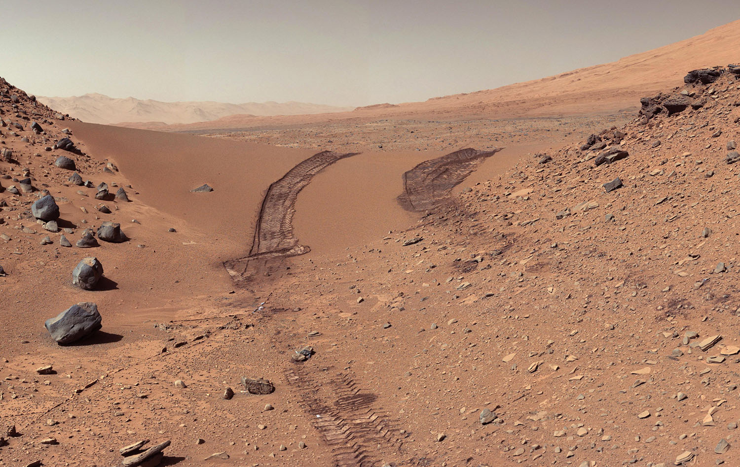This look back at a dune that NASA's Curiosity Mars rover drove across was taken by the rover's Mast Camera (Mastcam) during the 538th Martian day, or sol, of Curiosity's work on Mars (Feb. 9, 2014). The rover had driven over the dune three days earlier. For scale, the distance between the parallel wheel tracks is about 9 feet (2.7 meters). The dune is about 3 feet (1 meter) tall in the middle of its span across an opening called "Dingo Gap." This view is looking eastward. (NASA/JPL-Caltech/MSSS)