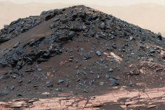 This dark mound, called "Ireson Hill," rises about 16 feet (5 meters) above redder layered outcrop material of the Murray formation on lower Mount Sharp, Mars, near a location where NASA's Curiosity rover examined a linear sand dune in February 2017.Researchers used the rover's Mast Camera (Mastcam) on Feb. 2, 2017, during the 1,598th Martian day, or sol, of Curiosity's work on Mars, to take the 41 images combined into this scene. The mosaic has been white-balanced so that the colors of the rock and sand materials resemble how they would appear under daytime lighting conditions on Earth. The view extends from west-southwest on the left to north-northwest on the right. The faint horizon in the distance beyond Ireson Hill is part of the rim of Gale Crater.  (NASA/JPL-Caltech/MSSS)