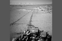 NASA's Curiosity Mars rover used the Navigation Camera (Navcam) on its mast for this look back after finishing a drive of 328 feet (100 meters) on the 548th Martian day, or sol, of the rover's work on Mars (Feb. 19, 2014). The rows of rocks just to the right of the fresh wheel tracks in this view are an outcrop called "Junda." The rows form striations on the ground, a characteristic seen in some images of this area taken from orbit. A panorama made from Navcam images taken during a pause to observe Junda partway through the Sol 548 drive is available at PIA17947.

For scale, the distance between Curiosity's parallel wheel tracks is about 9 feet (2.7 meters). This view is looking toward the east-northeast. (NASA/JPL-Caltech)